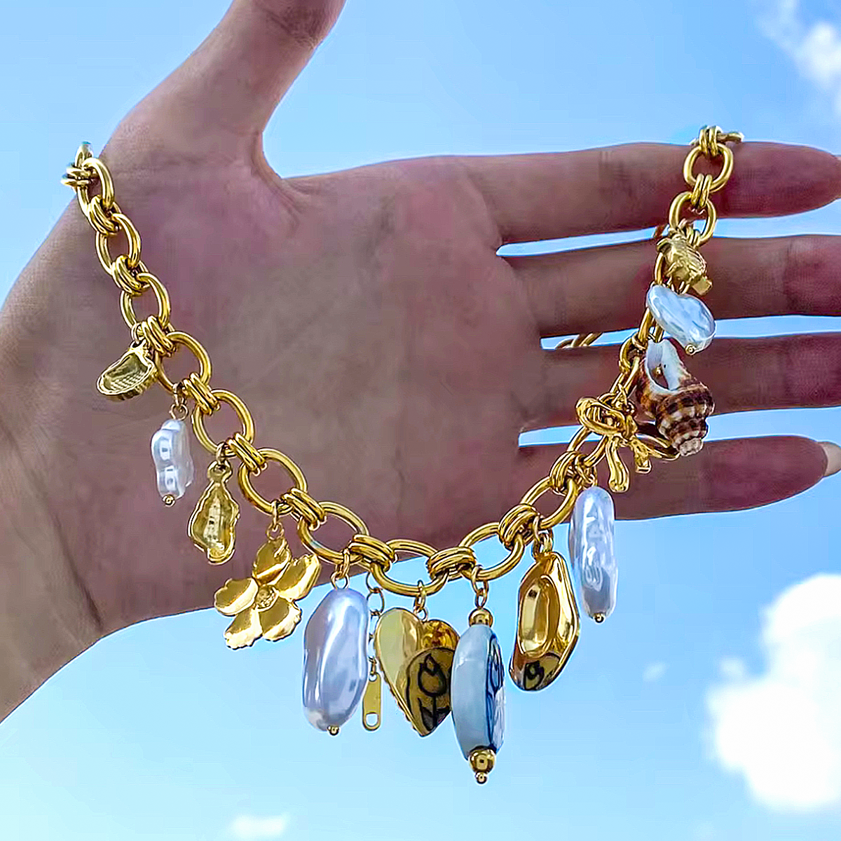 Návala 18K – Collar Dorado con Encantos Marinos y Detalles Cerámicos